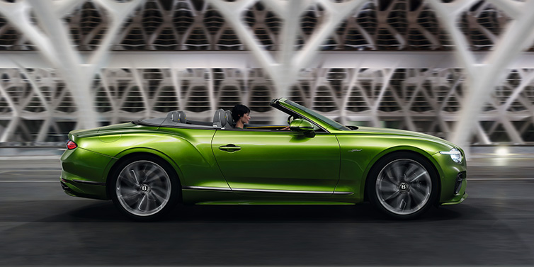 JCT600 Service Teeside Bentley Continental GTC Speed convertible side profile in Tourmaline Green paint driving dynamically on a bridge at night