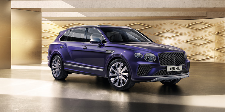 JCT600 Service Teeside Bentley Bentayga Extended Wheelbase Mulliner SUV front three quarter in Tanzanite Purple paint with a gold patterned background