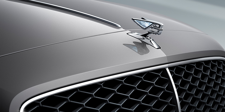 JCT600 Service Teeside New Bentley Flying Spur sedan bonnet detail in Silverlake paint with Illuminated Flying B bonnet badge and matrix grille with chrome surround