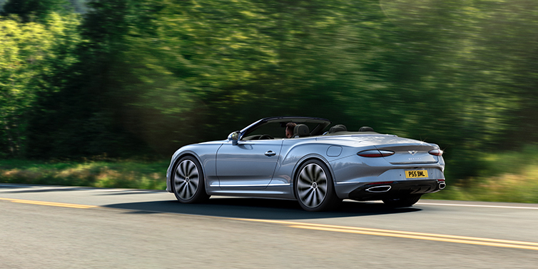 JCT600 Service Teeside New Bentley Continental GTC convertible side view in Silverlake paint with 22 inch ten spoke wheels driving dynamically on a country road