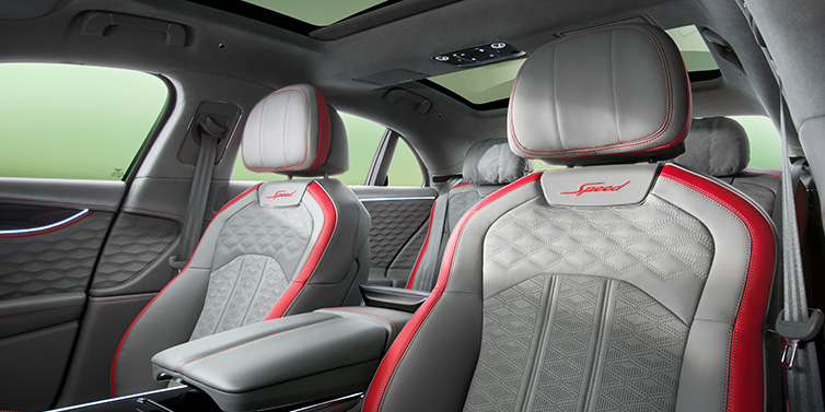 JCT600 Service Teeside Bentley Flying Spur Speed sedan interior showing front and rear seats in Hotspur red and Gravity Grey hides, with Speed seat emblems