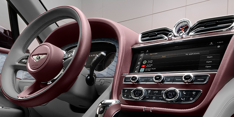 JCT600 Service Teeside Bentley Bentayga Atelier Edition SUV front interior steering wheel and MMI detail. Cricket Ball red and Gravity Grey hides